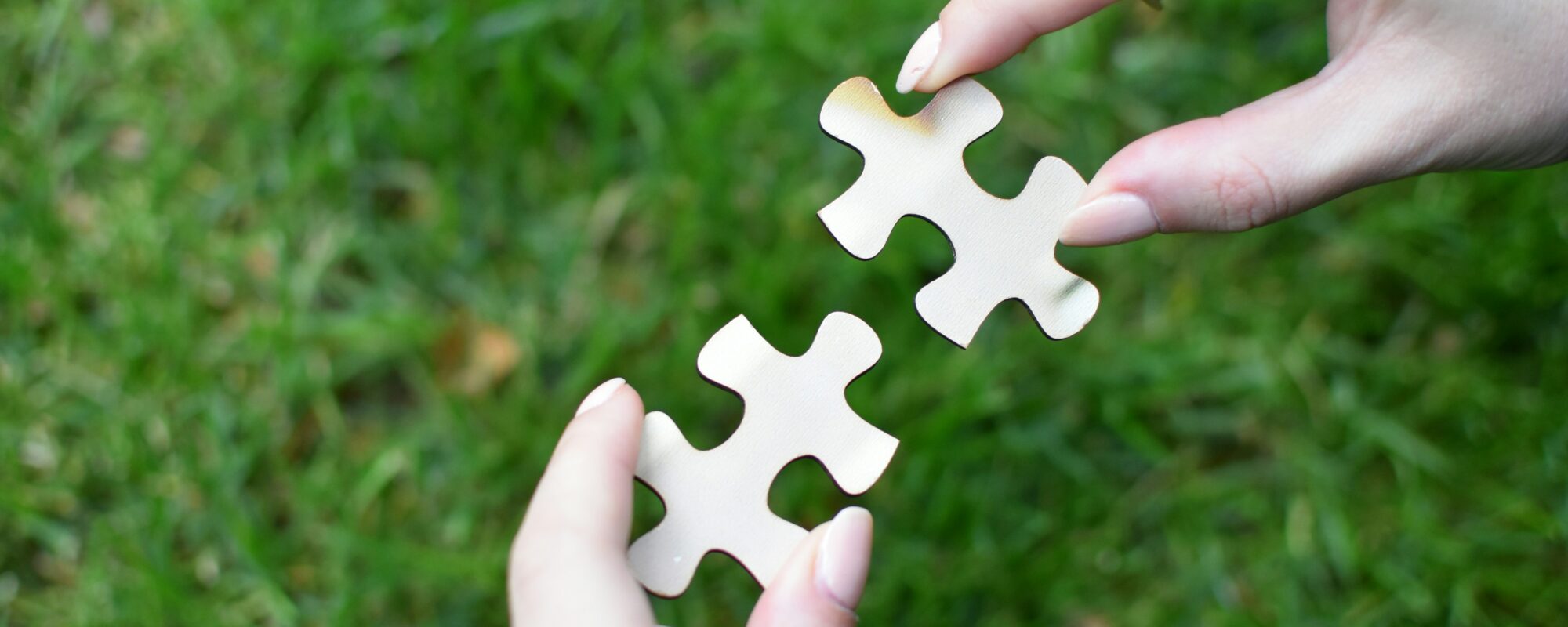 Zwei Hände halten zwei Puzzleteile (Symbolbild)