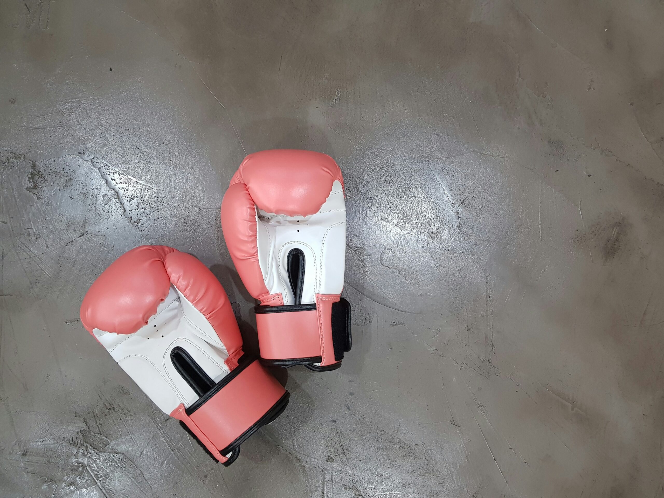 rosa Boxhandschuhe liegen auf dem Boden